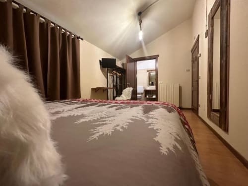 Superior King Room at Hotel Le Clou in Arvier with wooden flooring, brown curtains, TV, and modern amenities