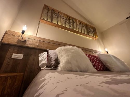 Camera Superiore King presso l'Hotel Le Clou con cuscini bianchi, cuscino rosso decorato, testiera in legno e illuminazione d'atmosfera