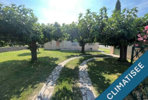 Lush garden pathway leading to La Conciergerie De Franck villa in Boissières with mature trees and green lawn