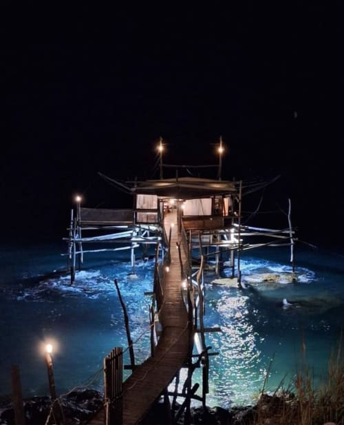 La piattaforma balneare Le Vajane di notte a Torino di Sangro, Italia con pontile illuminato in legno e vista sul mare
