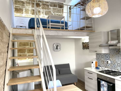 Modern loft studio at Catalogna10 in Alghero with mezzanine bed, kitchenette, and city view
