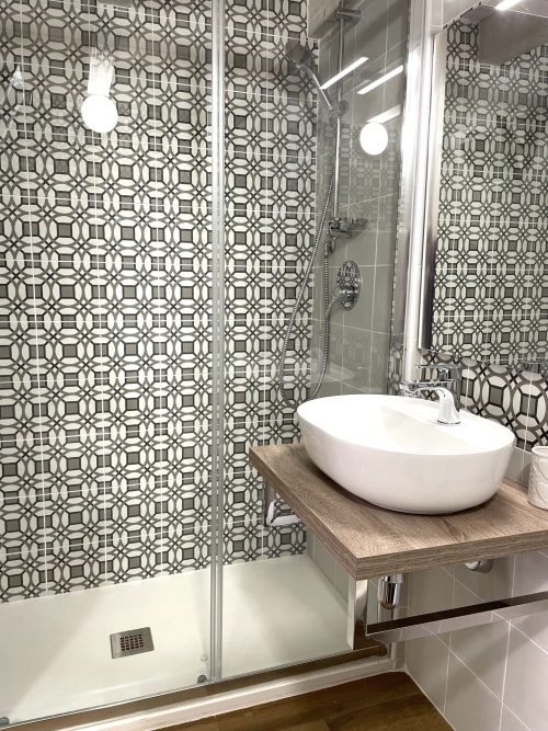 Modern bathroom at Catalogna10 Rooms e Loft in Alghero with geometric patterned tiles, vessel sink, and walk-in shower