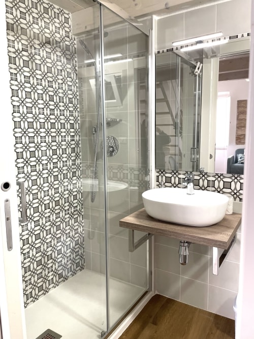 Modern bathroom at Catalogna10 Rooms e Loft in Alghero with geometric tile shower, white oval sink, and glass enclosure