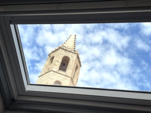 Medieval church tower viewed through skylight at Catalogna10 Rooms, Alghero city center