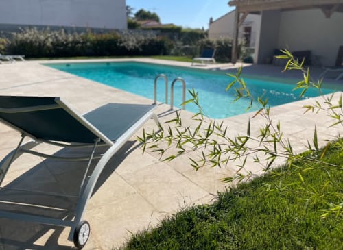 Sunny pool area at La Conciergerie De Franck villa in Boissières with lounge chairs and clear blue water
