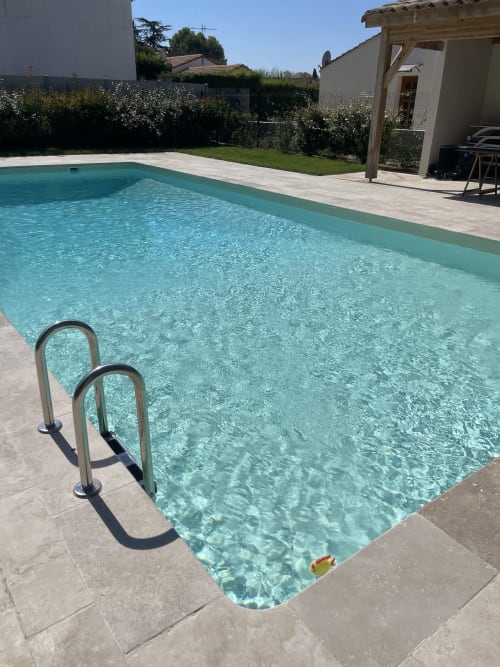 Crystal clear swimming pool with metal ladder at La Conciergerie De Franck villa in Boissieres, France