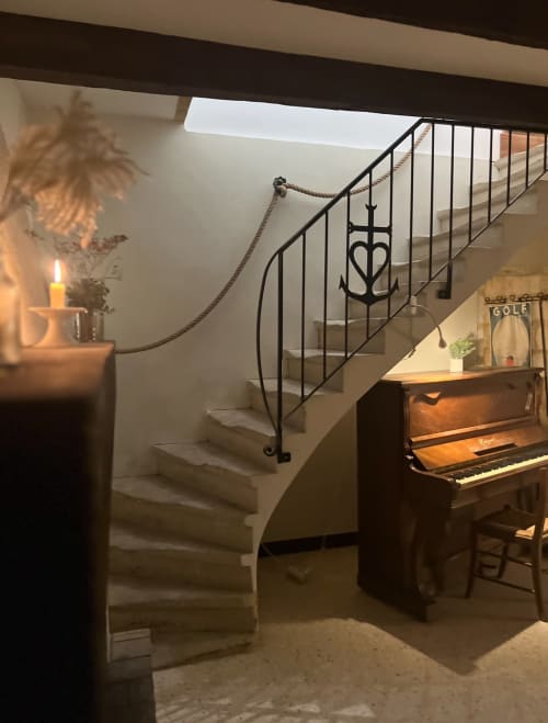 Elegant staircase with rope handrail and anchor detail at La Conciergerie De Franck villa in Boissières, with piano and