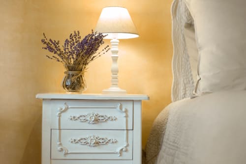 chevet de chambre avec lampe et vase rempli de lavande au mas des olivades