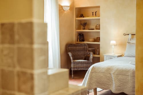 vue sur un coin d'une chambre dans le mas des olivades avec chaise en paille