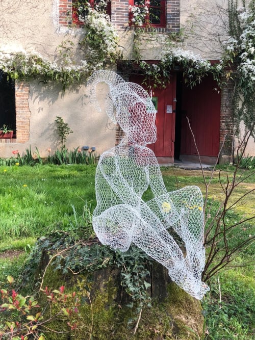 Sculpture blanche en maille d'une figure assise dans le jardin du Domaine de l'Ocrerie, Pourrain, France