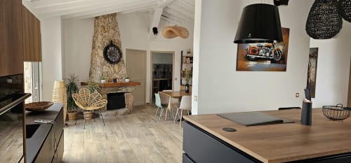 Modern villa interior with open-plan living, stone fireplace, dining area, and kitchen at Villas-Majos, Corsica