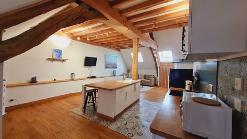 Loft studio moderne à Beaune avec poutres apparentes, îlot de cuisine, coin repas et vue sur la ville