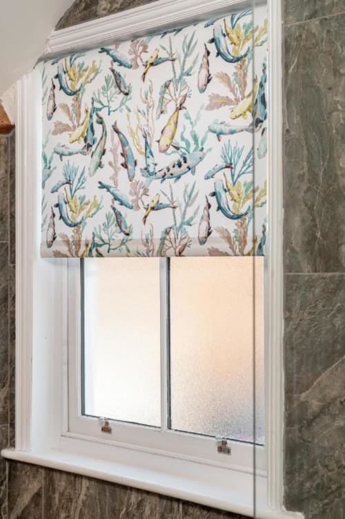 Close up image of one of the guest bathrooms; beautiful window treatment with blue and green fish patterns