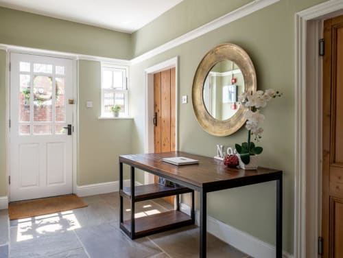 View of the bed and breakfast entryway with slate floors, wooden desk, and mirror