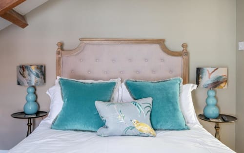 Bedroom 1 in the bed and breakfast; queen size bed with blue throw pillows, metal bedside tables, and blue lamps