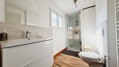Salle de bain moderne à la Conciergerie Des Climats de Beaune avec douche à l'italienne, vasque blanche et parquet