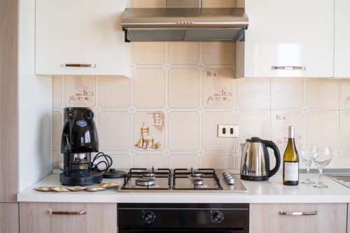 Cucina moderna con fornello a gas, caffettiera, bollitore e bottiglia di vino nell'appartamento con vista mare di Marina di Strongoli