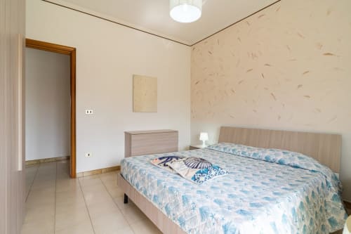 Camera spaziosa con letto matrimoniale, arredamenti in legno chiaro e vista sul mare presso Lux Immobiliare a Marina di Strongoli, Italia