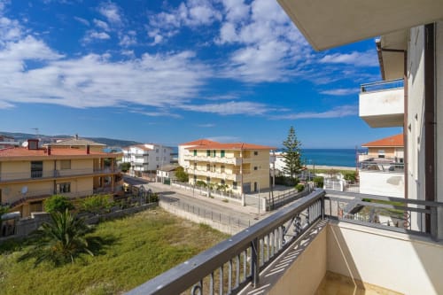 Vista dal balcone dell'appartamento spiaggia di Marina di Strongoli con vista mare, edifici moderni e cielo azzurro
