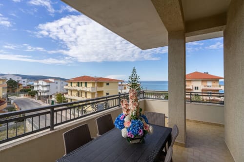 Terrazza con vista mare a Lux Immobiliare, Marina di Strongoli. Balcone arredato con fiori affacciato sulla cittadina costiera e lo Ionio