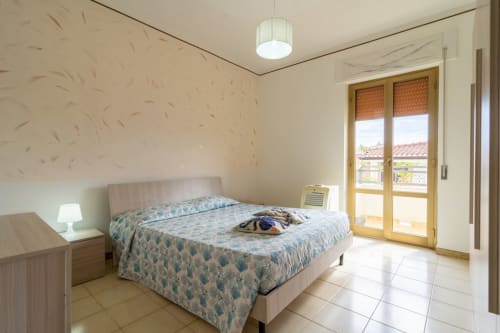 Camera luminosa con balcone vista mare, letto matrimoniale e comfort moderni dell'appartamento fronte spiaggia Lux Immobiliare a Marina di