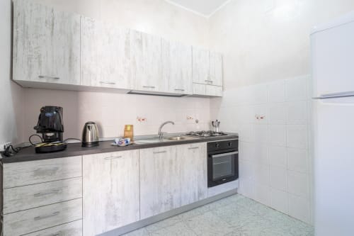 Cucina moderna con mobili bianchi, piano nero e elettrodomestici in acciaio inox in un appartamento fronte mare a Lux