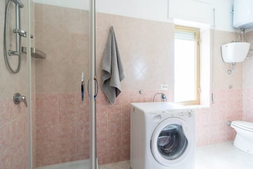 Moderno bagno con lavatrice, box doccia, wc e lavandino nell'appartamento fronte mare di Marina di Strongoli
