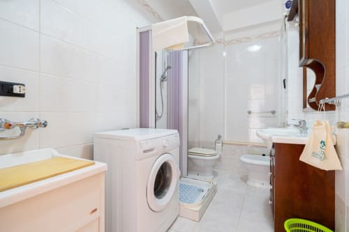 Bagno moderno con lavatrice, doccia, wc, bidet e lavabo nell'appartamento di Marina di Strongoli