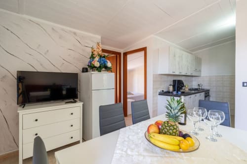 Moderna zona living con angolo cucina, TV, frutta fresca e vista mare presso Lux Immobiliare, Marina di Strongoli