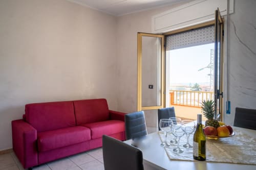 Luminoso appartamento con vista mare, divano bordeaux, zona pranzo e balcone affacciato sulla spiaggia di Marina di Strongoli
