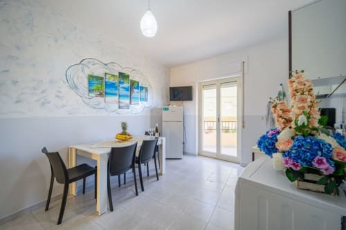 Luminoso appartamento con vista mare a Marina di Strongoli, tavolo da pranzo, cucina, fiori e accesso al balcone