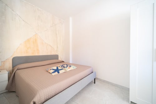 Camera minimalista con letto matrimoniale, testata grigia e terrazza con vista mare presso Marina di Strongoli B&B