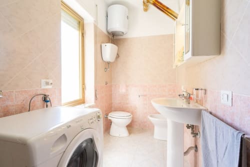 Bagno moderno a Casa a due passi dal mare, Marina di Strongoli, con lavabo a colonna, toilette e lavatrice