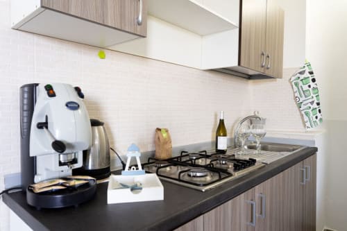 Cucina moderna nell'appartamento sulla spiaggia di Marina di Strongoli con fornello a gas, macchina espresso e vista sul mare