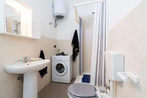 Bagno moderno in appartamento fronte mare a Marina di Strongoli con lavabo, lavatrice, WC e box doccia