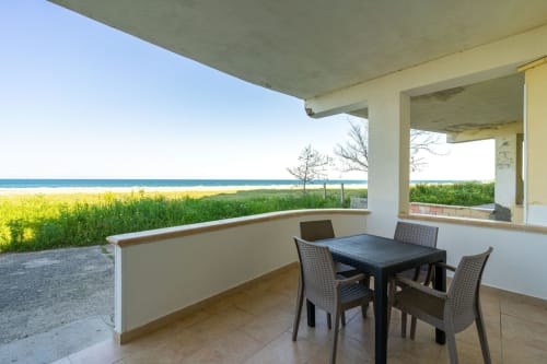 Terrazza fronte mare di Lux Immobiliare con tavolo, vista sul mare e accesso diretto alla spiaggia a Marina di Strongoli