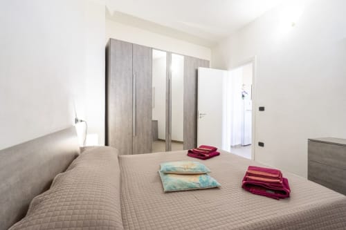 Camera da letto moderna con letto queen, armadio specchiato e vista mare nell'appartamento fronte spiaggia di Marina di Strongoli
