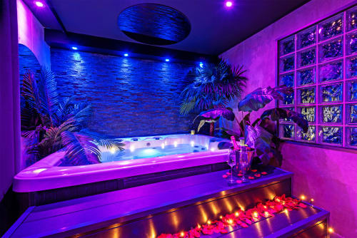 Spa privatif L'Insolite à Toulouse : jacuzzi néon, plantes tropicales et ambiance lumineuse