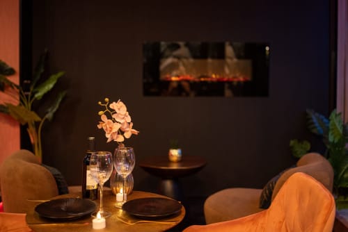 Élégante salle à manger du L'Insolite Spa Privatif à Toulouse avec vin, fleurs et ambiance intime