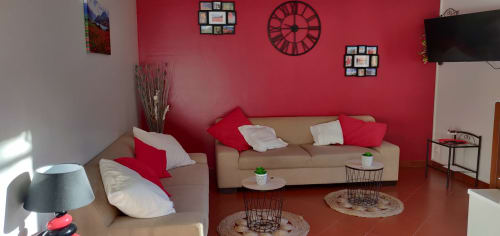 Lumineux séjour à Location MarjoRI avec canapé beige, murs rouges et mobilier vue montagne au Lauzet-Ubaye