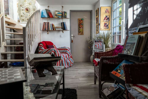 Salon bibliothèque cosy avec fauteuils et décoration basque pour la détente des hôtes au moulin.