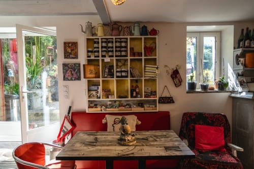 Étagère de produits locaux et coin repas convivial avec banquette rouge au Moulin de Pascale.