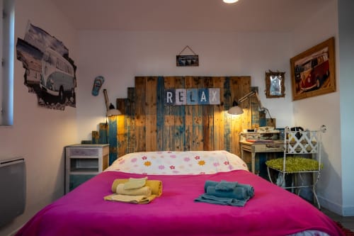 Découvrez la chambre de 3 personnes du Moulin de Pascale, un ancien moulin de 1650 à Espelette. Cette chambre d'hôtes offre un lit 2 places, un lit 1 place, une élégante tête de lit, des rangements pratiques, un bureau et une décoration soignée. Profitez d'un séjour unique dans ce lieu atypique avec restauration sur place.