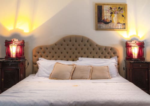 Chambre élégante de la Deluxe Room Le Camelie à Dimora i Manichei, Monforte d'Alba, avec tête de lit capitonnée et lampes de chevet rouges.