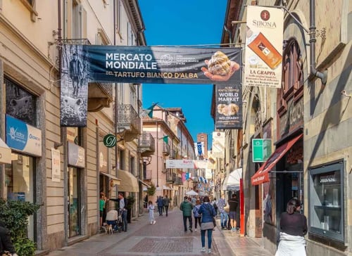 Affascinante via in ciottolato a Monforte d'Alba con negozi e insegne di mercato vicino a Dimora i Manichei