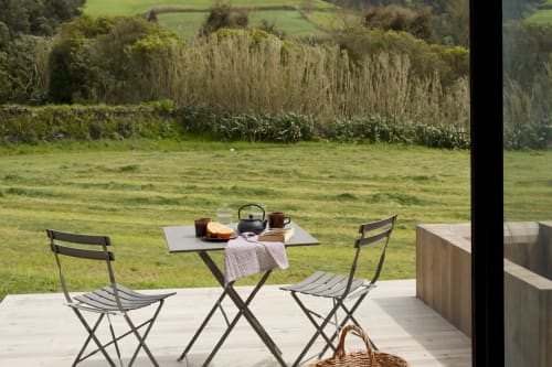 Private balcony with folding chairs and small table overlooking pastoral countryside at Villa Várzea, Portugal