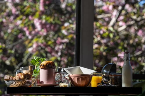 Petit-déjeuner gourmand au Moulin de Pascale à Espelette : croissant frais et jus d'orange face au jardin en fleurs.