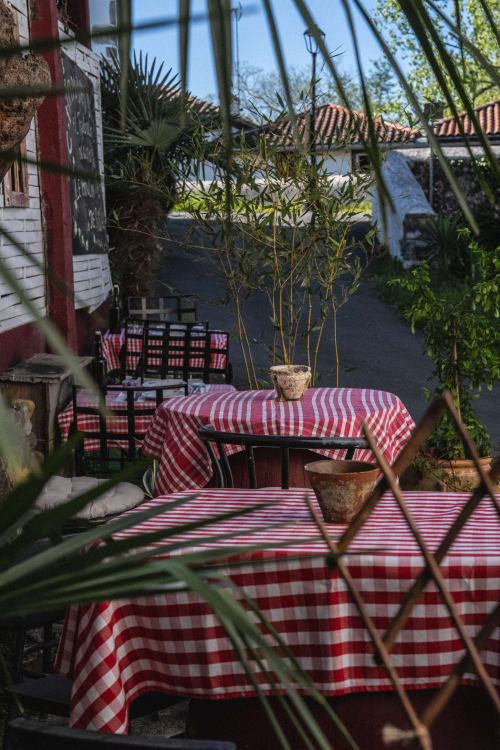 Ambiance guinguette au restaurant du Moulin : tables aux nappes à carreaux pour un déjeuner champêtre et local au Pays Basque.
