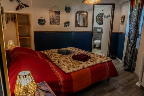 Vue d'ensemble de la Chambre d'hôtes Ainhoa, décoration soignée avec mur bleu, mobilier en bois et accès direct à la salle de bain privée à Espelette.