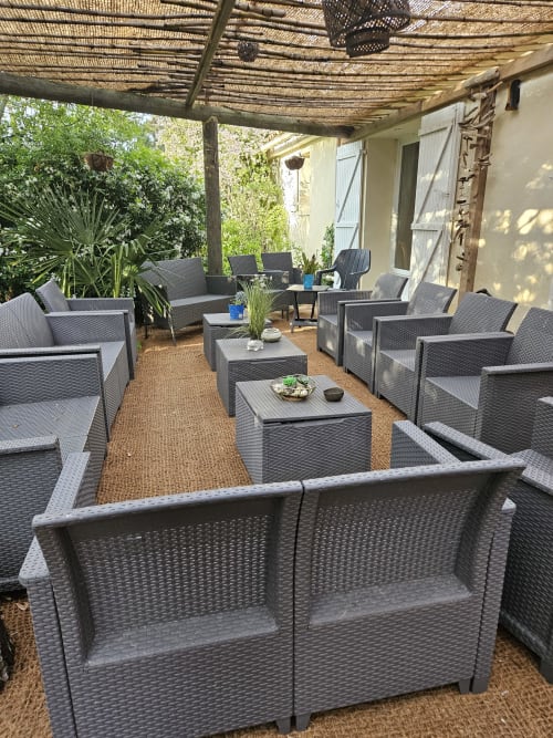 Außenpatio-Lounge im Le Manoir Lacustre mit grauem Rattanmöbel, Tischen und schattigem Pergola in Queyrac